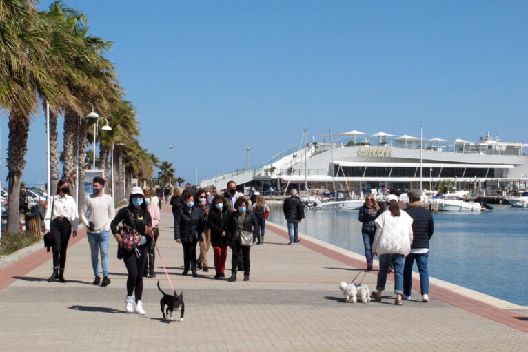 Gente paseando por el puerto de Dénia con mascarillas