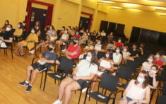 adolescentes sentados con distancia de seguridad durante lla clausura del curso de ciclomotor