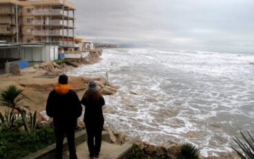 vecinos observando los destrozos de la playa les deveses