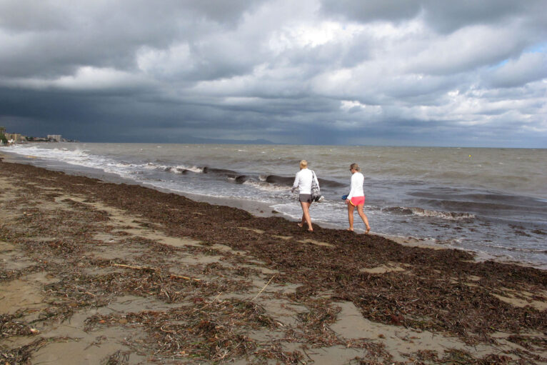 Pareja paseando por la orilla tras la tormenta