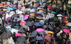 falleros bajo los paraguas para resguardarse de las lluvias