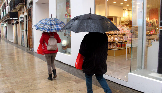 Imagen: Gente paseando con paraguas bajo la lluvia en el centro de Dénia