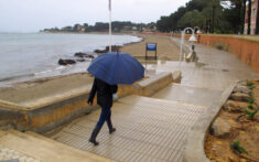 persona paseando bajo la lluvia en el paseo de la marineta cassiana de denia archivo